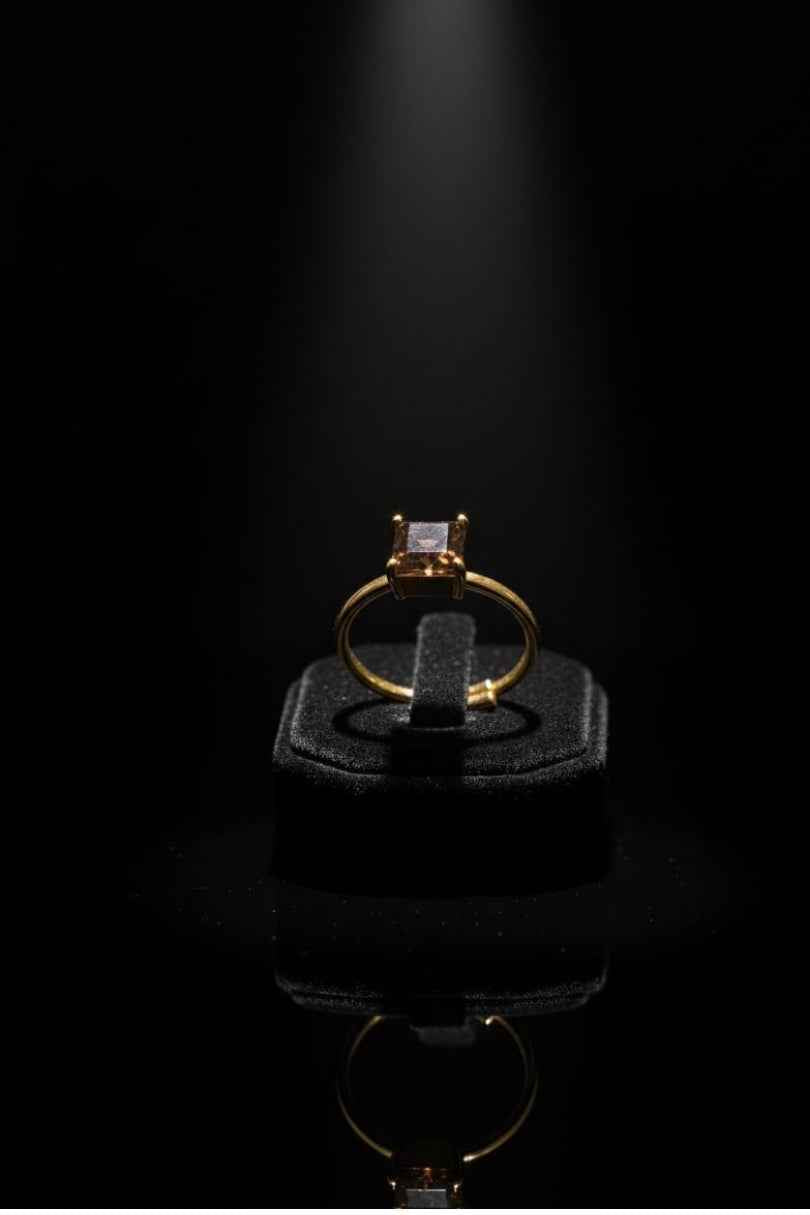 Anillo dorado con piedra marrón cuadrada