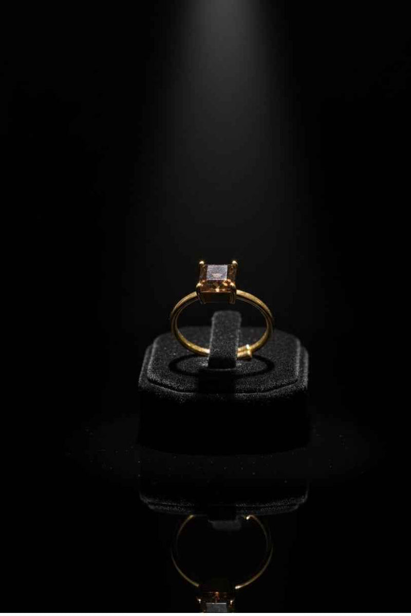 Anillo dorado con piedra marrón cuadrada