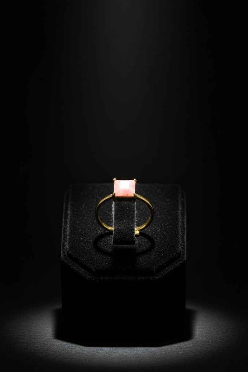 Anillo dorado con piedra rosa cuadrada
