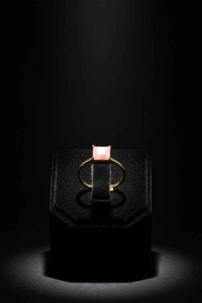 Anillo dorado con piedra rosa cuadrada